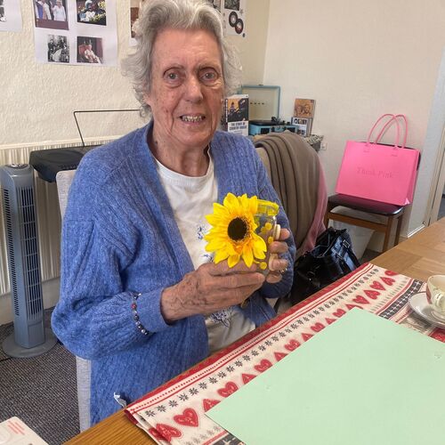 Elderly lady sat at Your Care's Dementia Day Club in Bristol, posing with her pot she decorated at her arts and craft session.