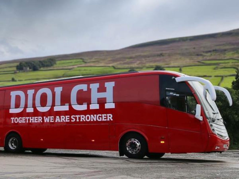 Red wrapped Caetano Levante with white vehicle graphics on side.