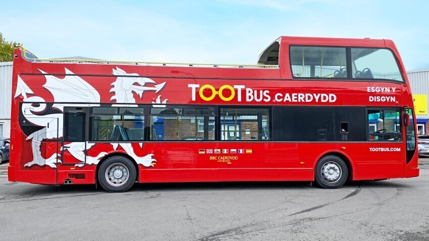 Red Ayats Bravo city open top bus with Toots company branded vinyl graphics.