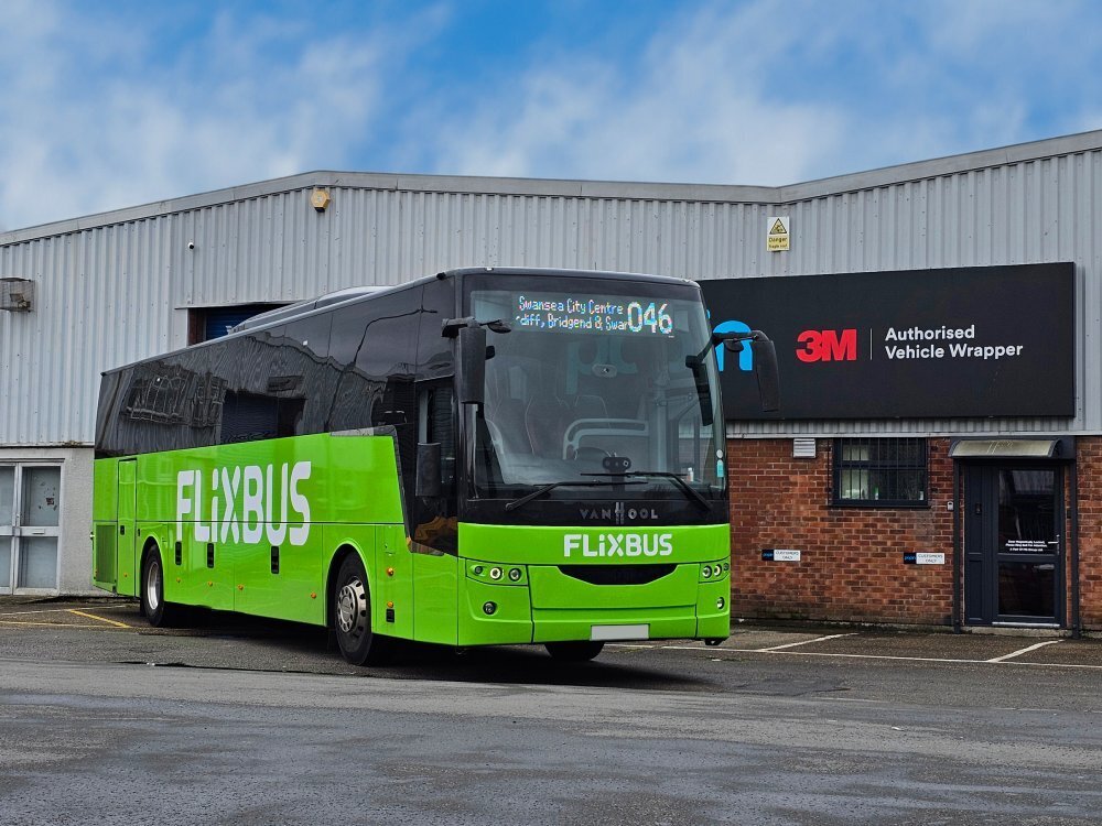 Flixbus from a bus fleet with new green vehicle wrap and white letter graphics outside Popin in Cardiff.