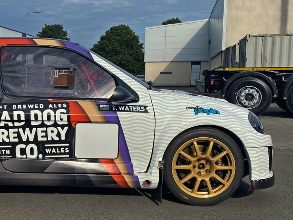 Front end of Renault Clio V6 with branded company vehicle wrap.