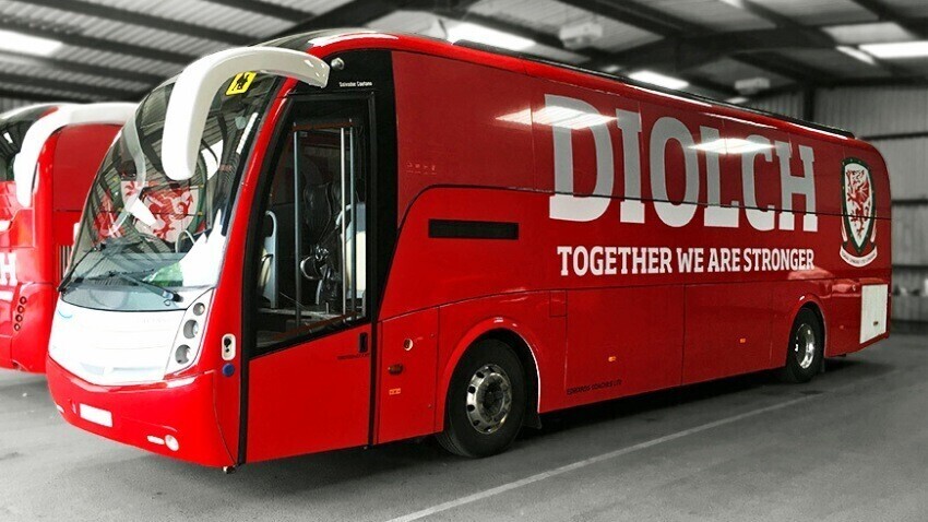 Red and white vehicle wrapped Caetano Levante coach with FA Wales branded vinyl graphics.