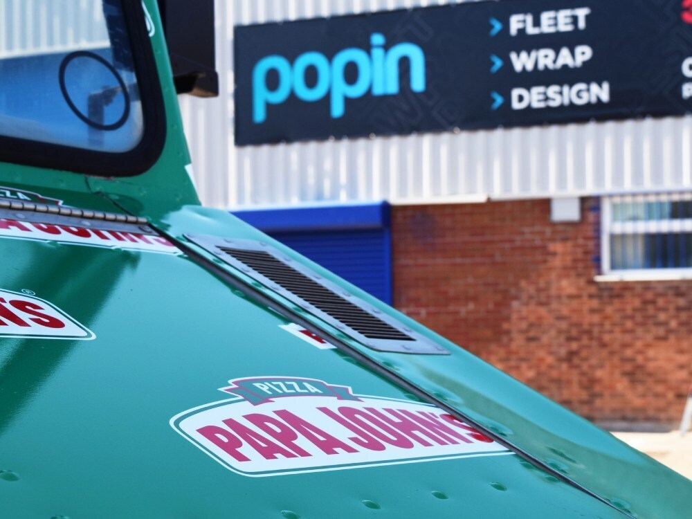 Close up of Papa Johns pizza vehicle graphics installed on a GMC truck parked outside Popin in Cardiff.