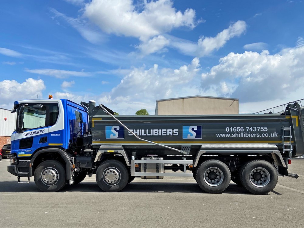 Side profile of a Scania truck with newly installed branded vinyl graphics.
