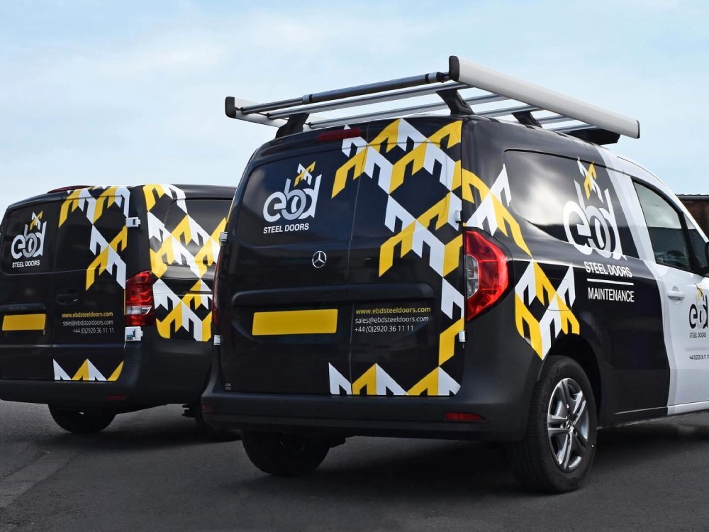 Branded vehicle graphics on fleet of company vans.