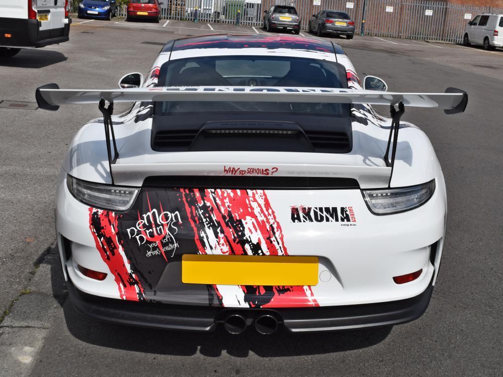 Black and red vehicle wrap and graphics on white Porsche GT3 RS.