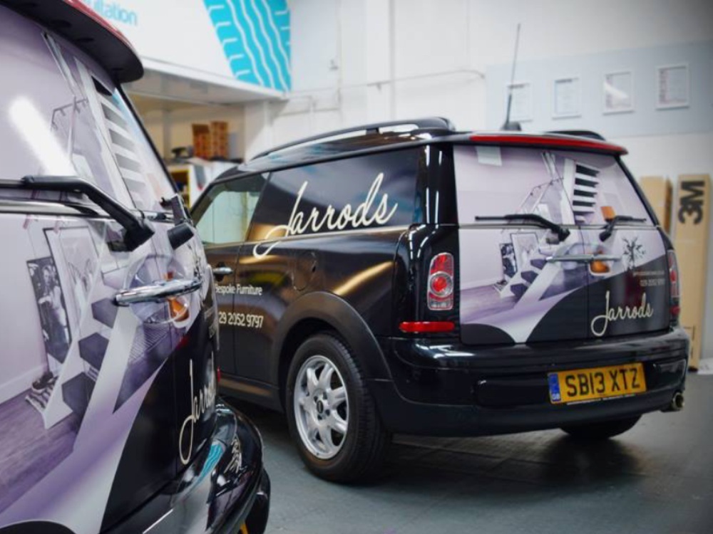 Matching branded vehicle wraps on company car fleet.