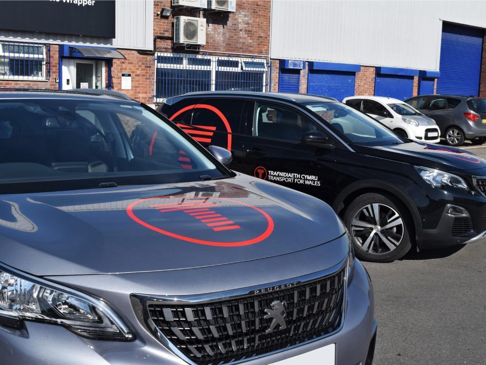 Company Peugeot 3008 cars with branded vinyl graphics.