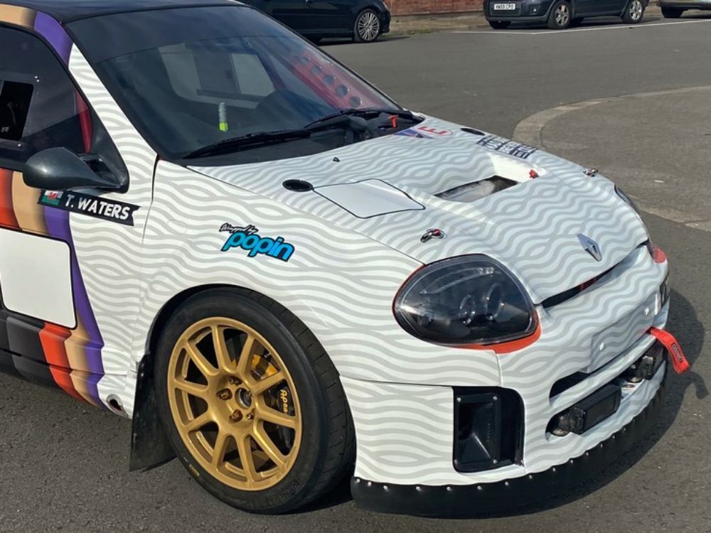 Creative vehicle wrap on front end of company Renault Clio V6.