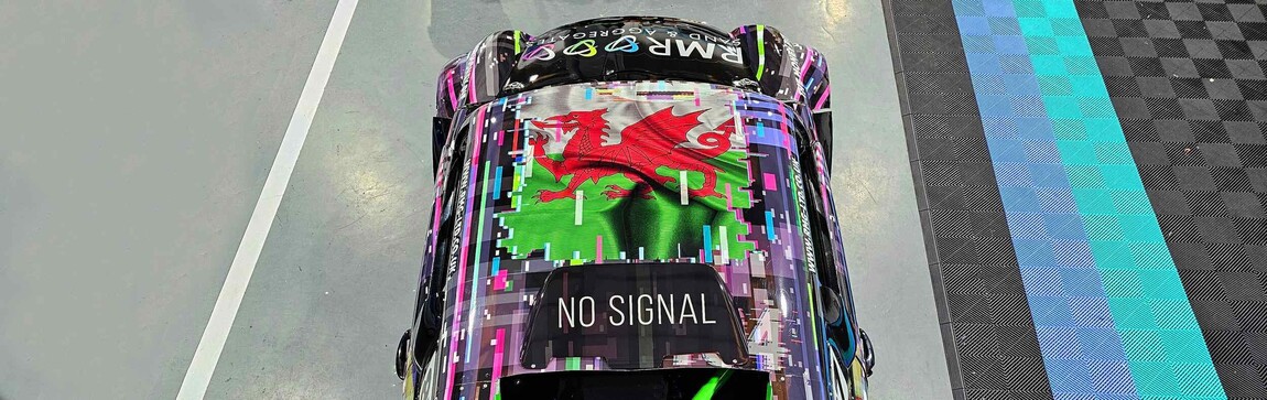 Aerial shot of a motorsport livery with Welsh flag as a vinyl graphic on the roof.