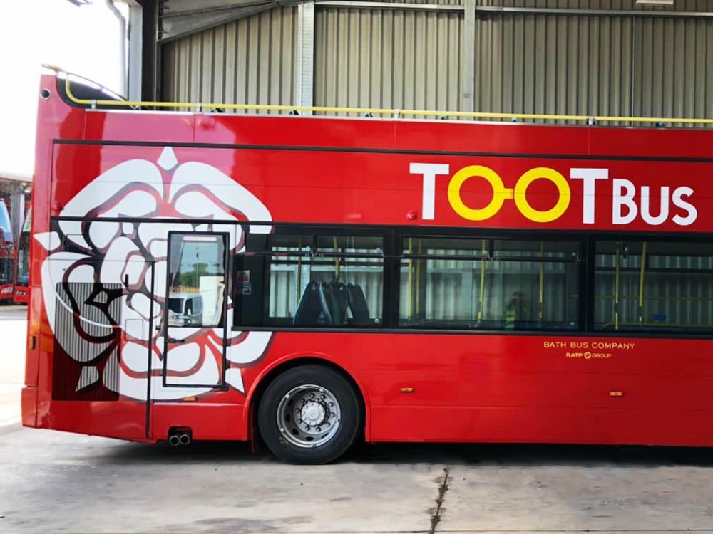 White flower design vinyl graphics on Tootbus Bath Optare VLE open top bus.