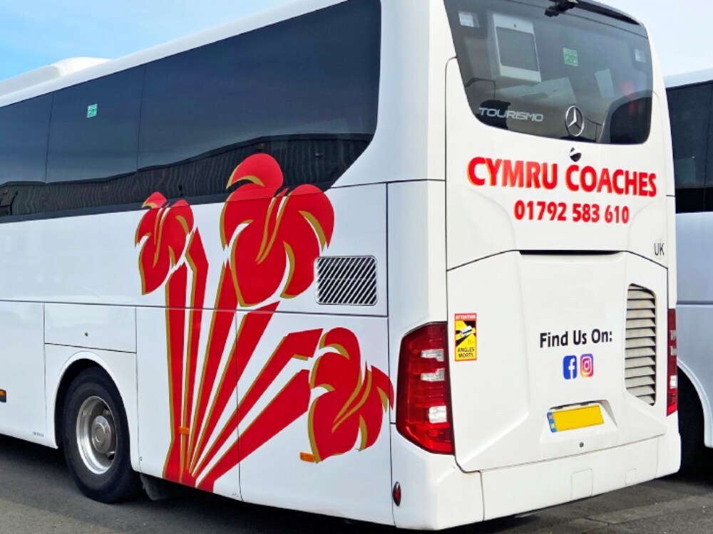 Detail of red Welsh three feathers vinyl graphics design on white Mercedes Tourismo coach.