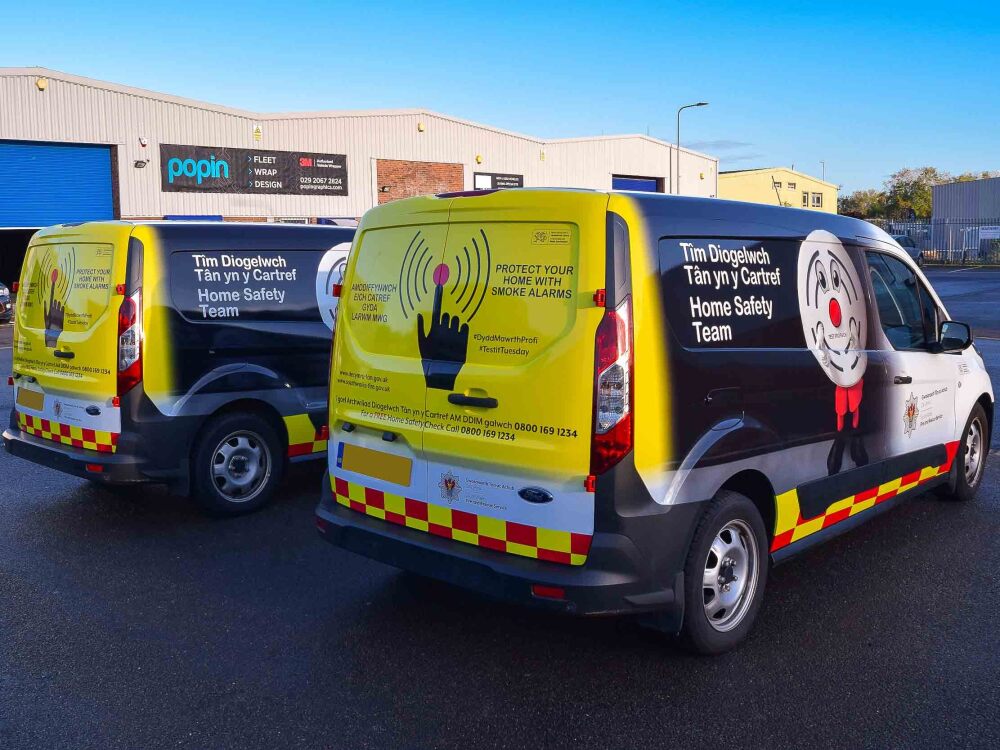 Fleet of Ford Transit Connect vans with matching vehicle wraps for South Wales Fire and Rescue Services outside Popin in Cardiff.