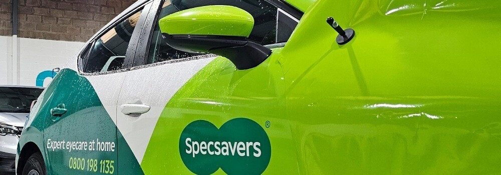 Branded vehicle wrap being installed onto a Specsavers company car.