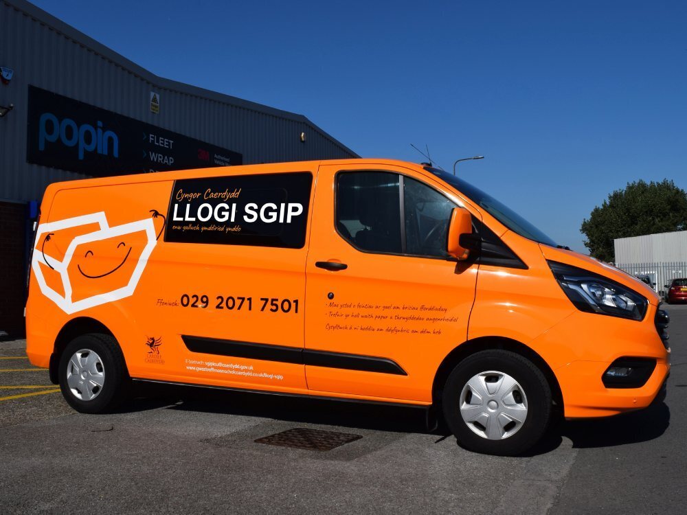 Orange vehicle wrap on company Ford Transit van for Cardiff Council.