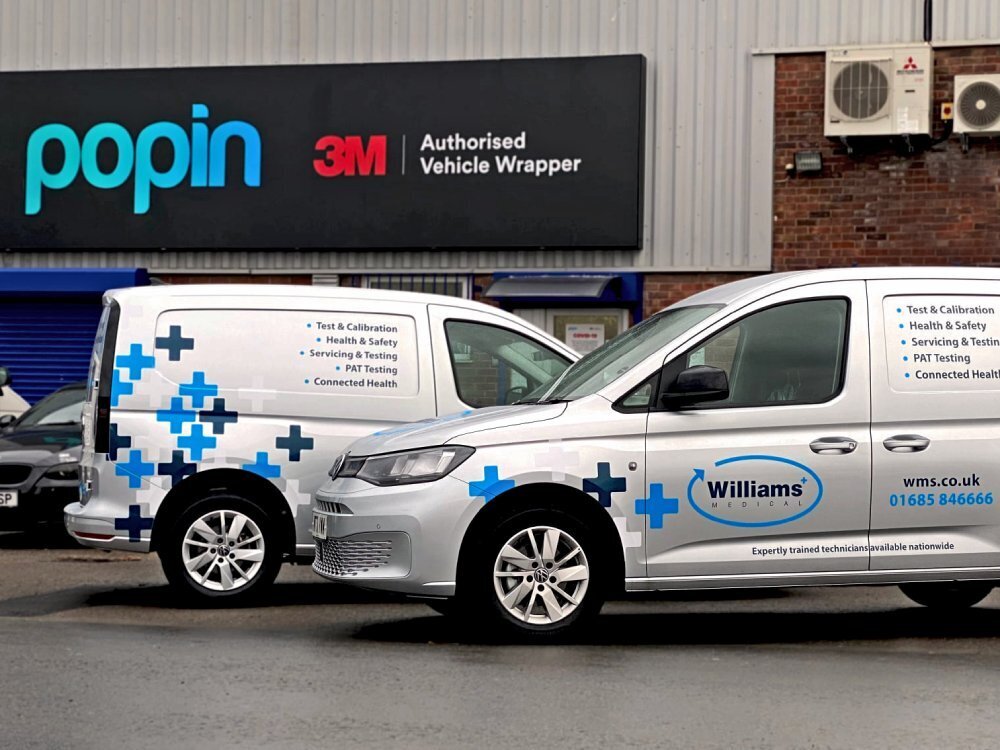 Branded vehicle wraps on company van fleet outside Popin Graphics in Cardiff.