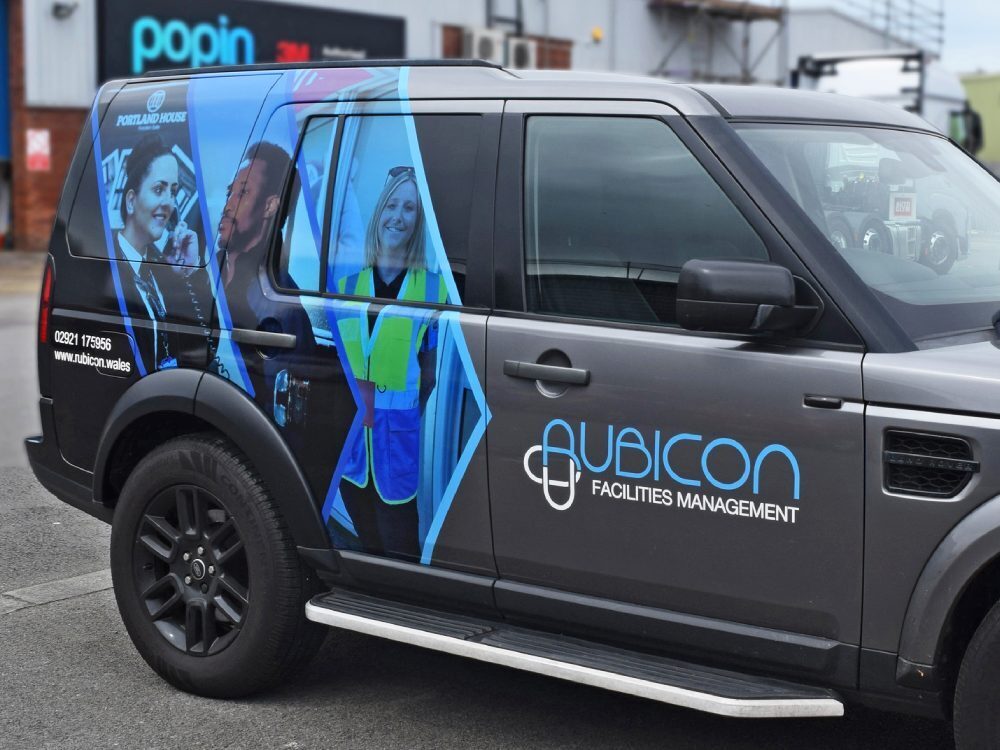 Partial vehicle wrap on grey company Land Rover Discovery.