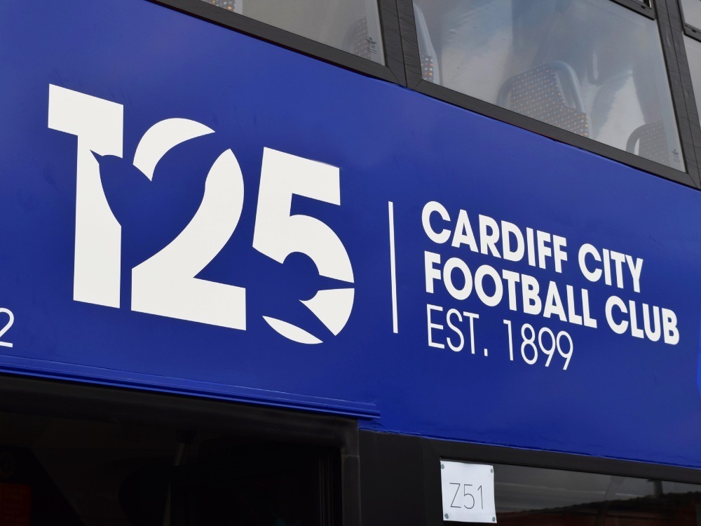 White Cardiff City football club graphics on blue Alexander Dennis Enviro 400 bus.
