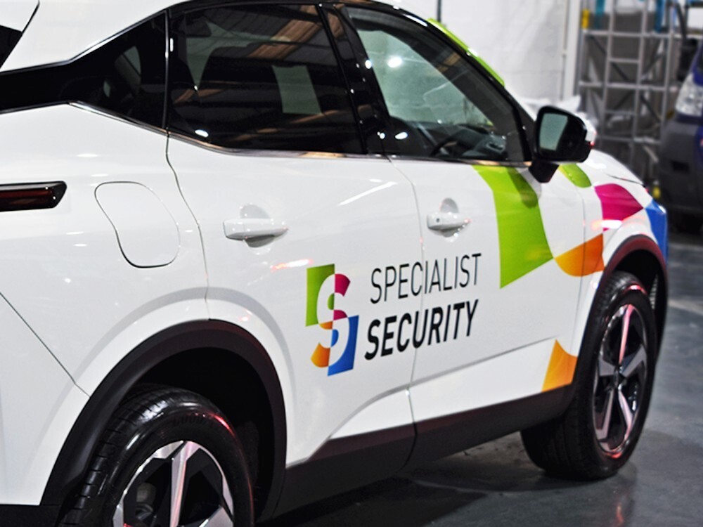 Branded vinyl graphics on white company Nissan Juke.