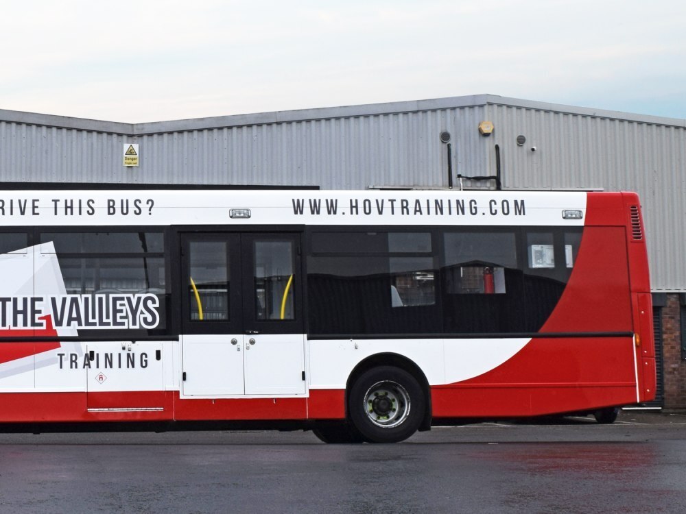 Back end of Alexander Dennis Enviro 300 driver training bus with branded company vinyl graphics.