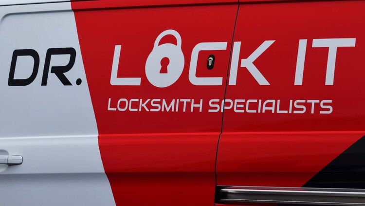 Red, white, and black vehicle vinyl graphics on local locksmiths tradesman van.