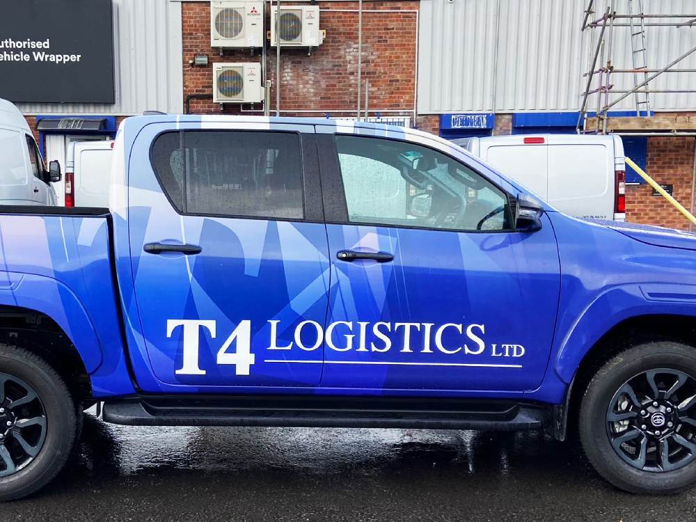 Blue full vehicle wrap and branded white vinyl graphics on Toyota Hilux company car.