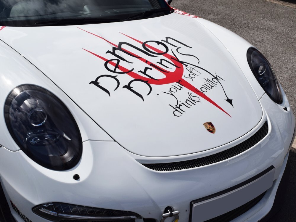 Branded company vinyl graphics on bonnet of white Porsche GT3 RS.