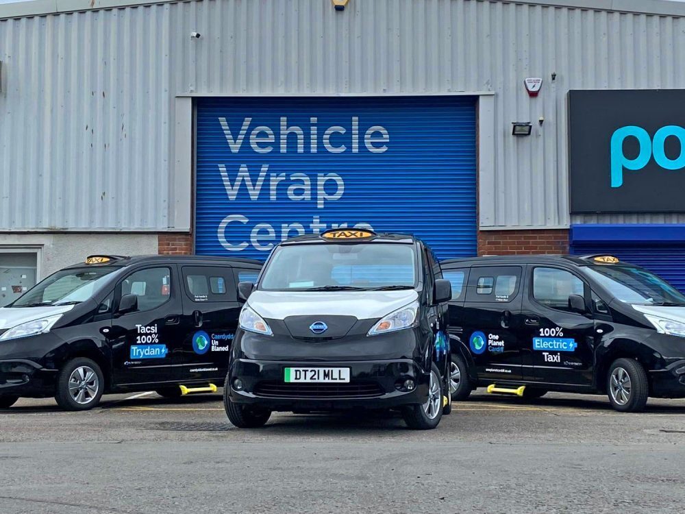 Vehicle wraps and graphics on a fleet of taxi vans.