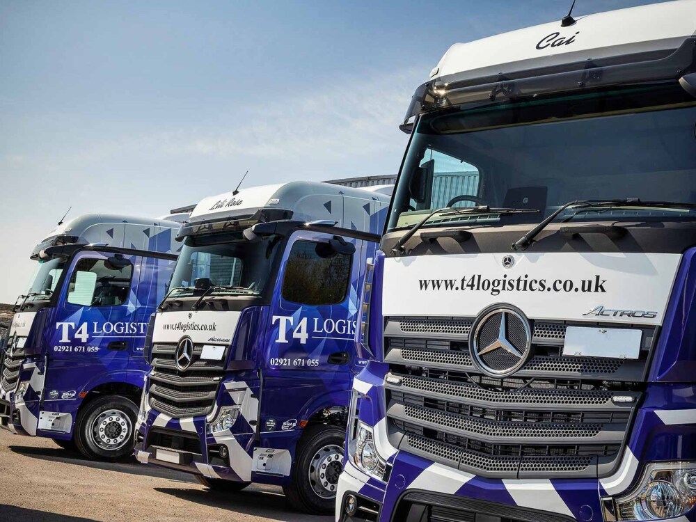 Fleet of Mercedes Actros trucks with matching blue and white wraps and graphics for T4 Logistics.