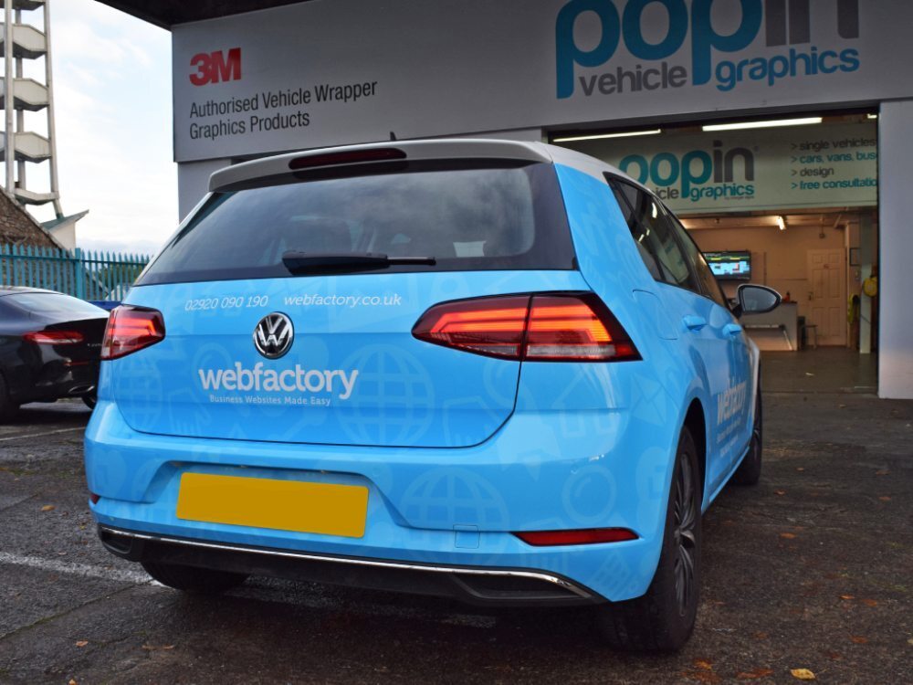 Blue branded vehicle wrap on rear of Volkswagen Golf company car outside Popin Graphics in Cardiff.