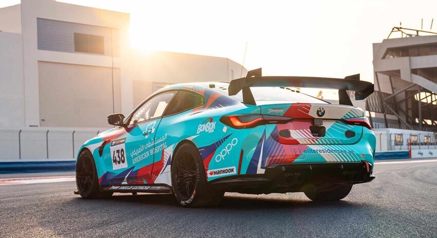 BMW M4 GT4 motorsport race car with full printed vinyl wrap displaying sponsor logos