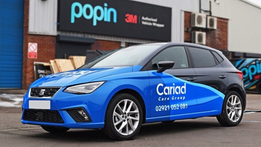 Branded blue and black vehicle wrap on SEAT Ibiza outside Popin in Cardiff.