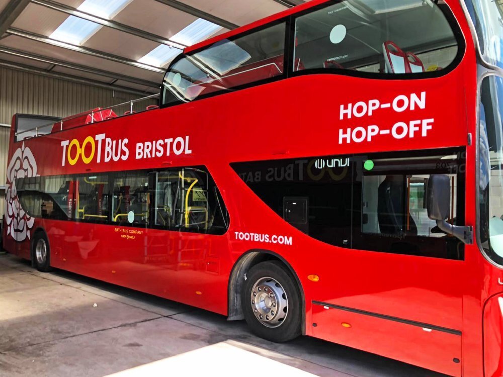 Red UNVI Urbis open top tour bus with Tootbus Bristol advertising vinyl graphics.