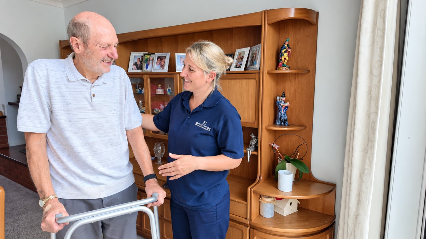 Older man using a walking frame with an Estuary Physio physiotherapist during a home visit