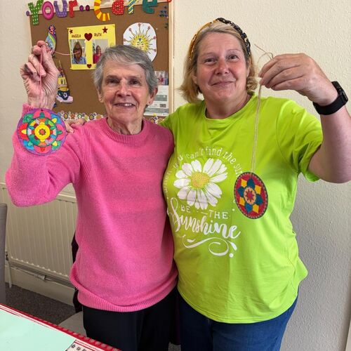Elderly lady and Your Care's activity coordinator Ruth, proudly showing off their arts and crafts at Your Care's Dementia Day Centre in Bristol