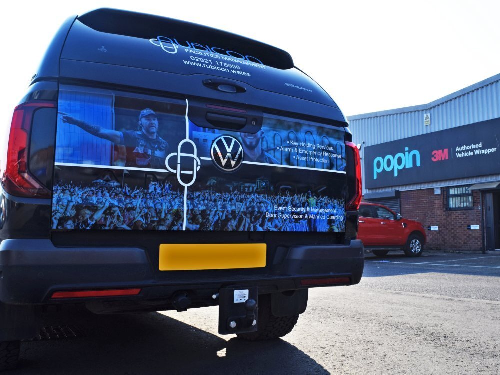 Branded partial vehicle wrap on rear of Volkswagen Amarok company car outside Popin in Cardiff.