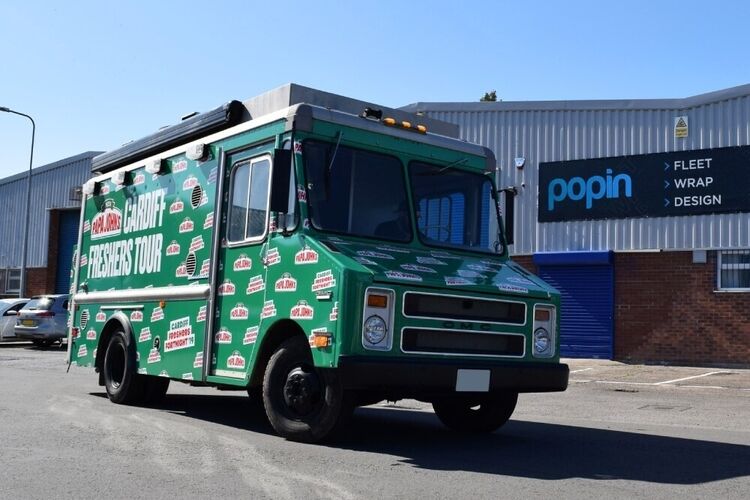 GMC truck with green bespoke Papa Johns pizza vehicle wrap and graphics outside Popin in Cardiff.