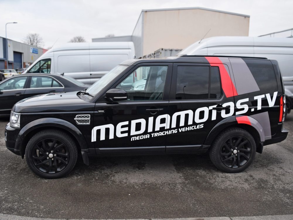 Bold branded vinyl graphics on black company Land Rover Discovery.