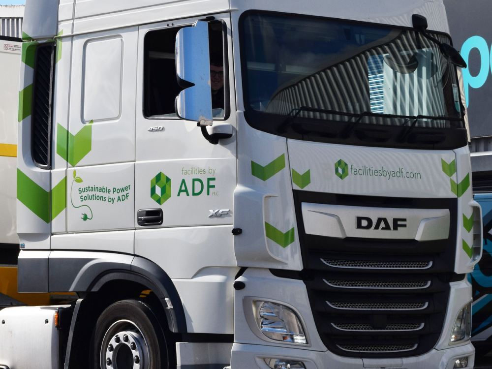 Company branded vehicle vinyl graphics on white truck cab.