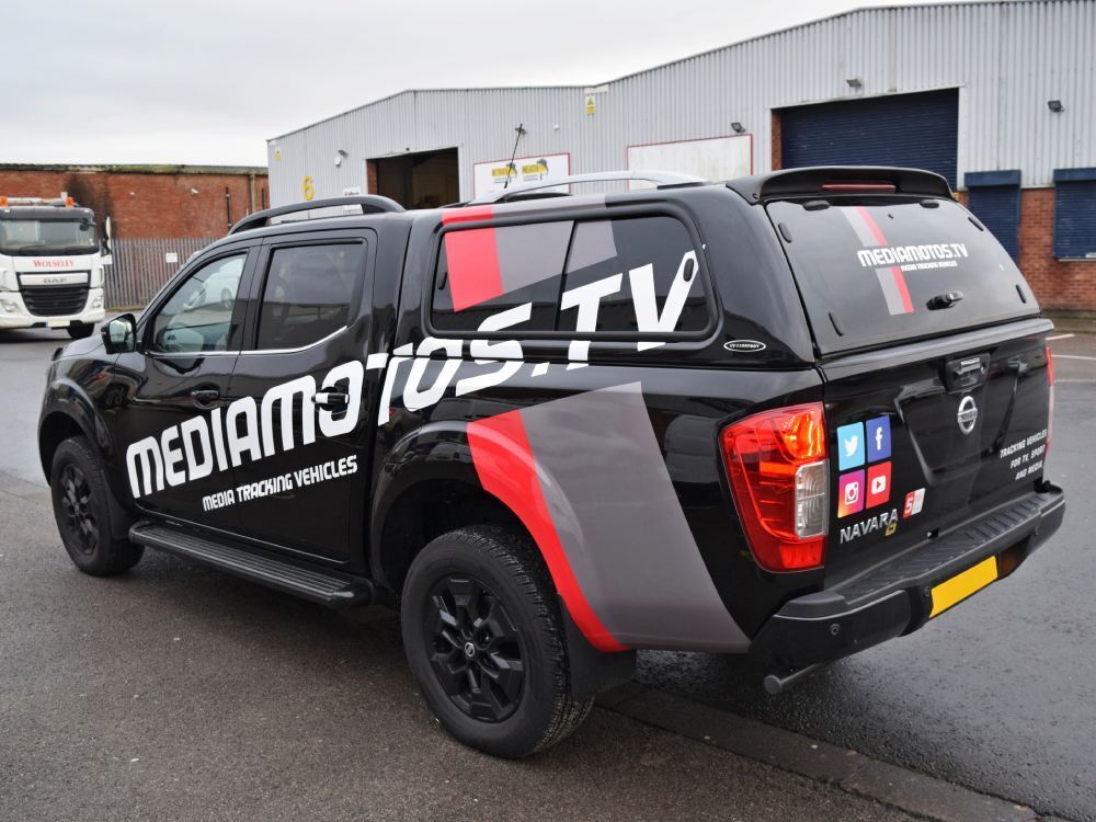 Black company Nissan Navara with red, grey and white vinyl graphics.