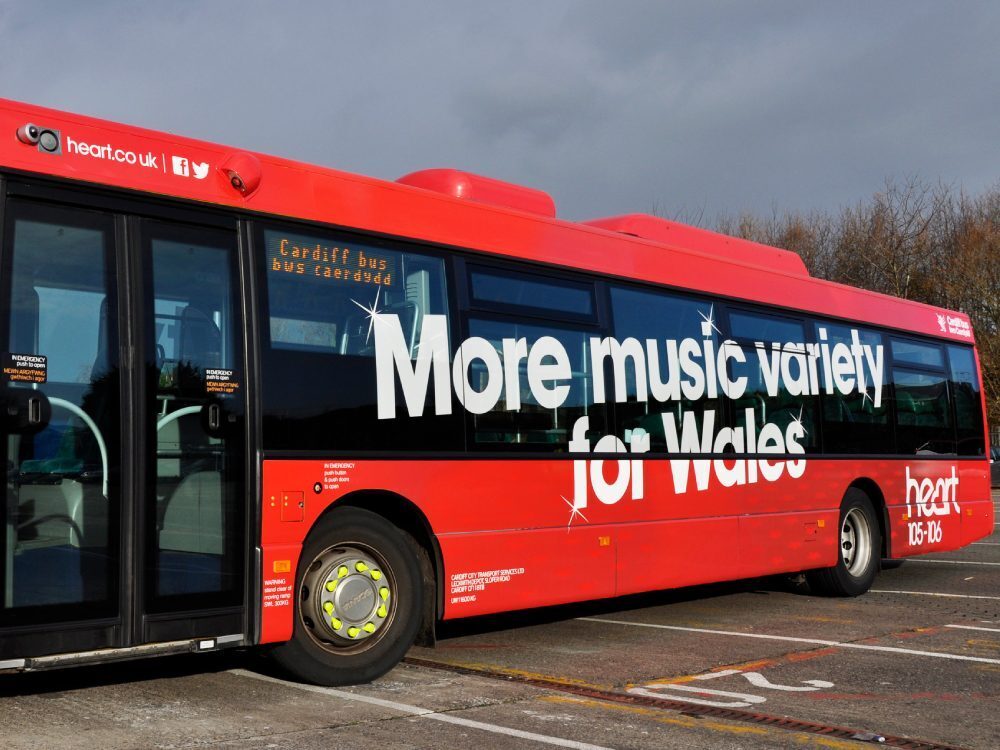Red Scania Omnilink Cardiff Bus with Heart FM promotional vinyl graphics.