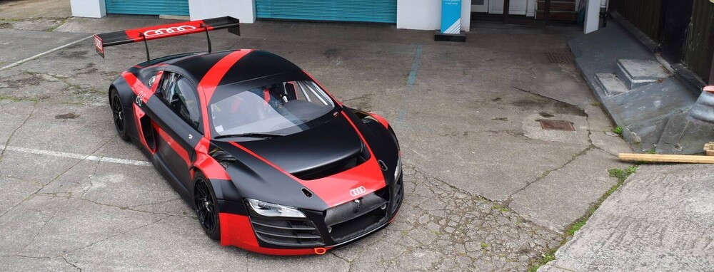 Motorsport livery on Audi R8 blending black matte vinyl with red gloss for contrast effect.