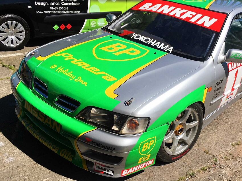 Bright green and yellow motorsport livery with easy-to-read sponsor graphics on race car.