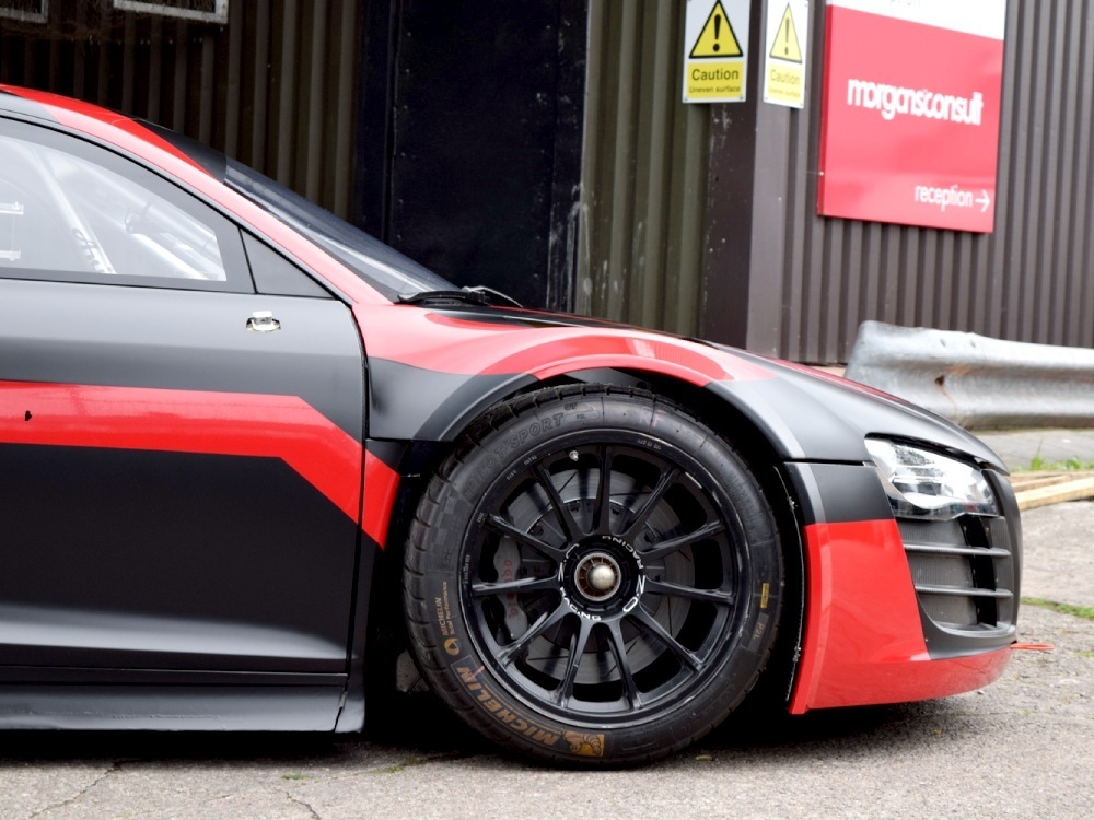 Front wheel of Audi R8 with red and black race car vinyl wrap