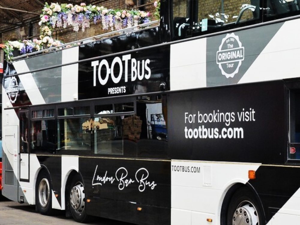 Black and white vehicle wrap and branded graphics on side of Tootbus London Bar Bus Optare VXE.