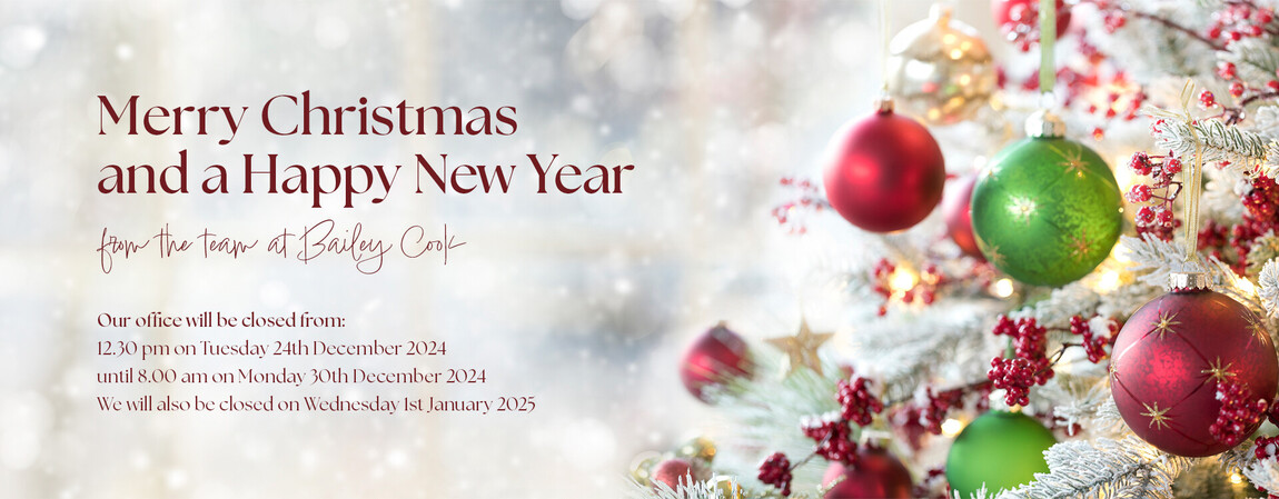 An example banner image showing a frosty scene of a white christmas tree covered in red and green baubles and red berries. To the left of the tree is a merry christmas message wishing a merry christmas and a happy new year.