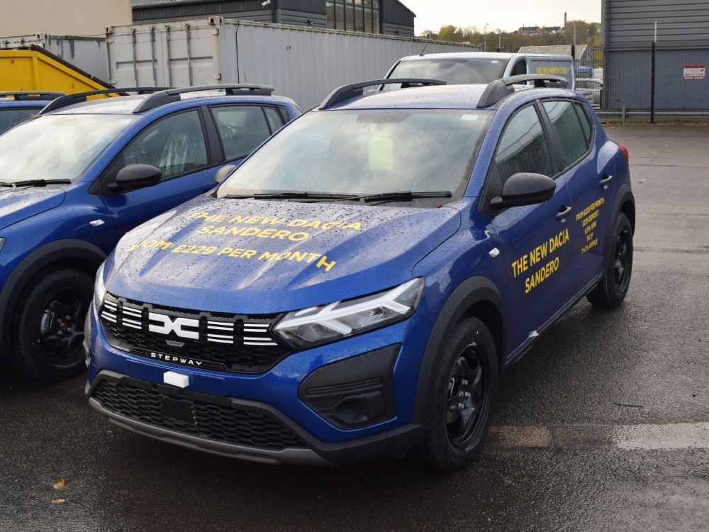Blue company Dacia Sandero car with yellow vinyl graphics.