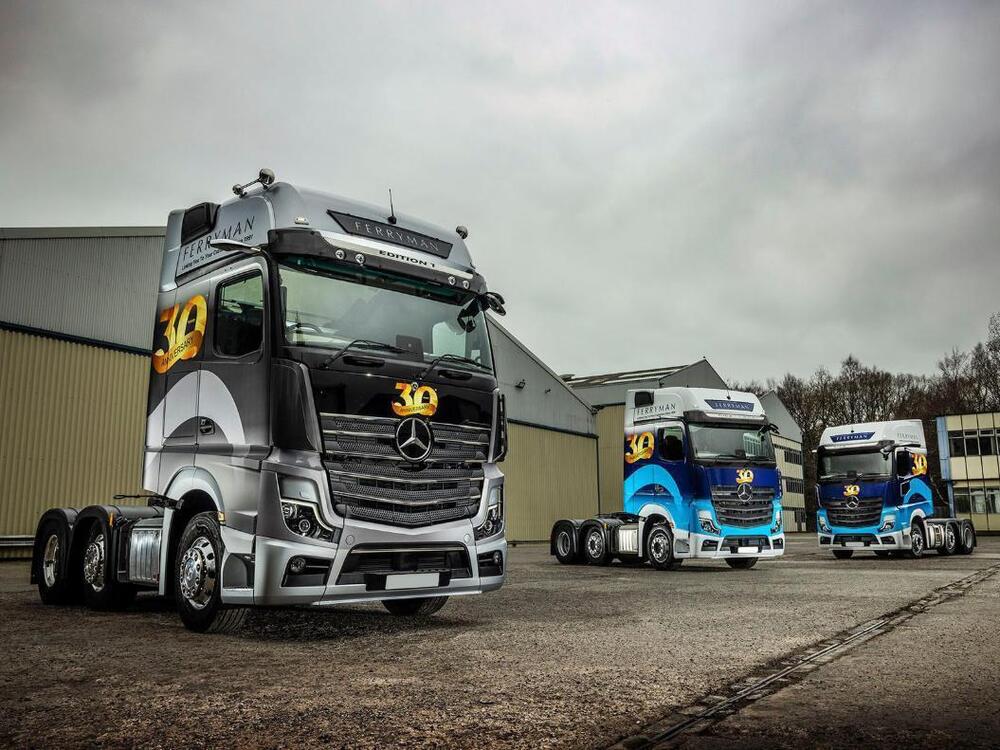 Fleet of three Mercedes company trucks with branded vinyl liveries.
