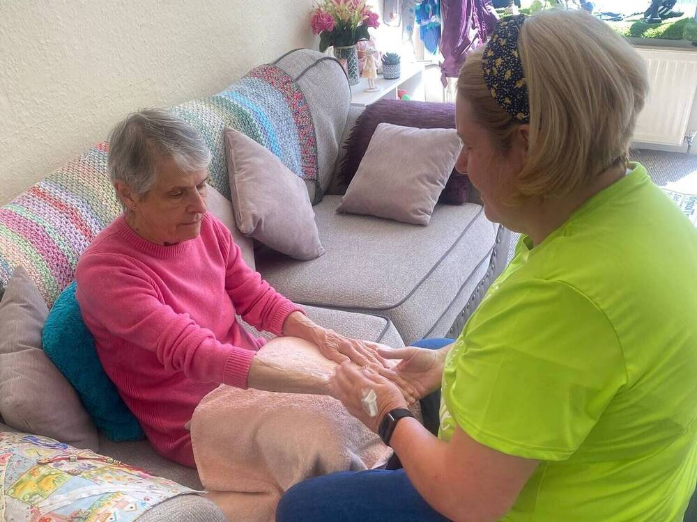 Elderly lady enjoying her pamper session with a hand massage at Your Care's Dementia Day Club in Hanham, Bristol