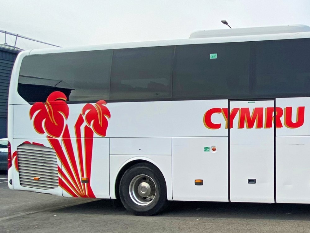 Welsh three feathers vinyl graphics design on rear side of white Mercedes Tourismo coach.